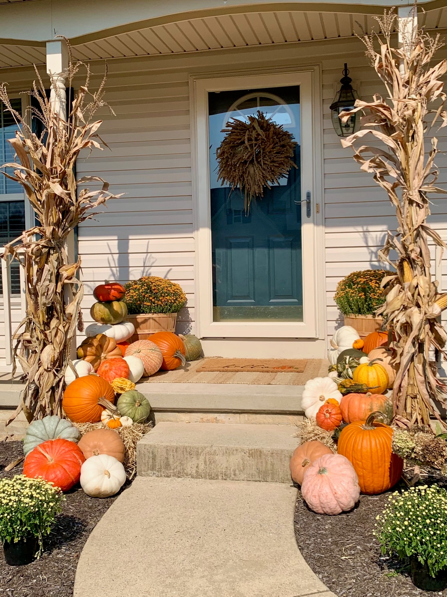 Porch with corn stalks and pumpkin arrangement